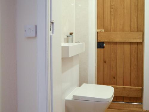 a bathroom with a white toilet and a sink at The Dairy House in Creebridge