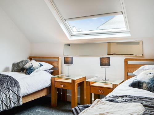 a bedroom with two beds and a skylight at Chapel Mouse Cottage in Cockermouth
