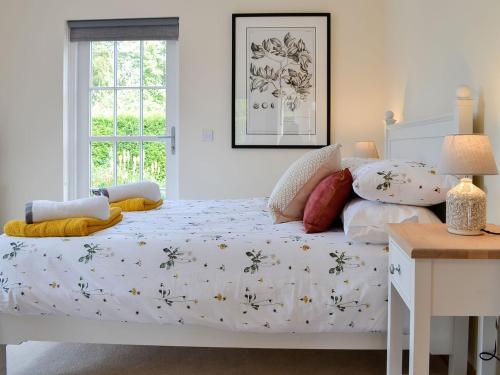 a bedroom with a white bed with flowers on it at The Garden Rooms in Montrose