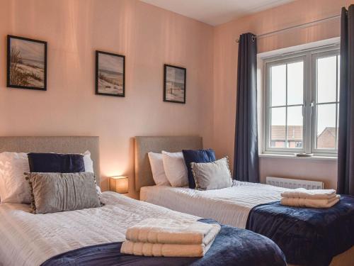 1 dormitorio con 2 camas y ventana en Harlie House en Whitby