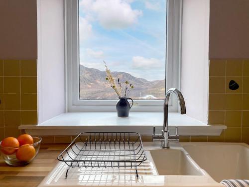 a kitchen with a sink and a window with a view at The Grain Store in Aberarder