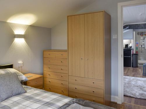 a bedroom with a dresser and a large cabinet at Cuillin View Apartment - Uk12529 in Arisaig