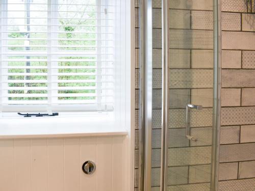 um chuveiro na casa de banho com uma janela em Strawberry Cottage em Combe Martin