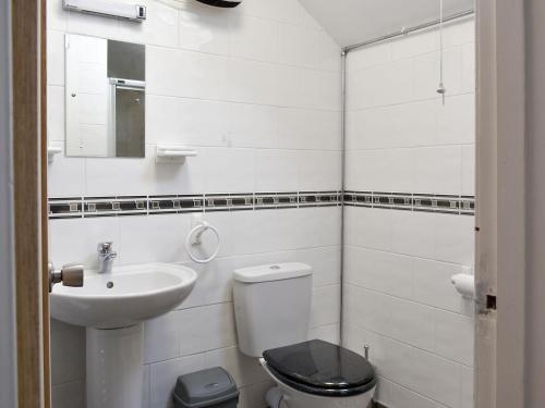 a white bathroom with a toilet and a sink at Cuillin View Apartment - Uk12529 in Arisaig