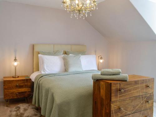 a bedroom with a bed and a chandelier at River View in Dumfries