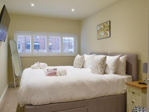 Beachcomber Corner في ليثام سانت أنيه: غرفة نوم بسرير كبير عليها شراشف ووسائد بيضاء