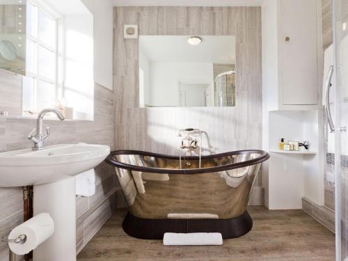 a bathroom with a tub and a sink at The Gatehouse Cottage in Wells