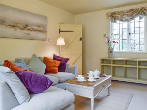 a living room with a couch and a table at Dulcie Cottage in Benson