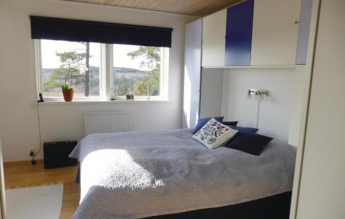 a bedroom with a bed and a large window at Lovely Home In Grdinge With Sauna in Sibble