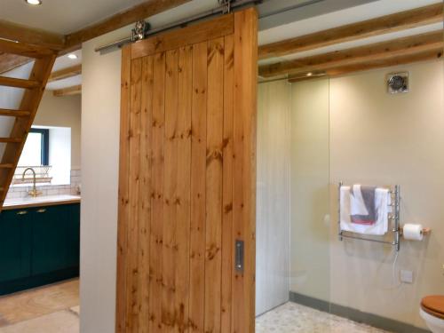 a wooden sliding door in a bathroom with a toilet at Harsondale Bothy in Langley