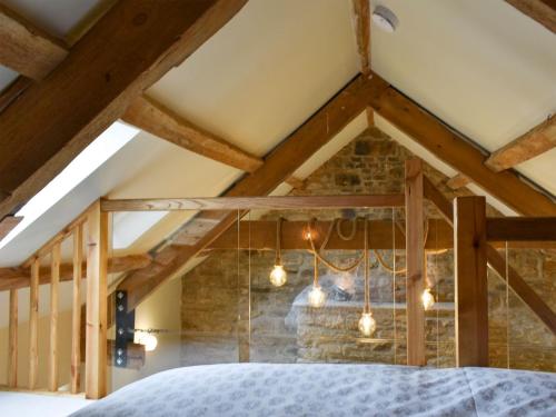 a bedroom with a bed and a stone wall at Harsondale Bothy in Langley