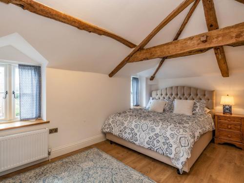 a bedroom with a bed and a window at Clematis Cottage in Thorpe Market