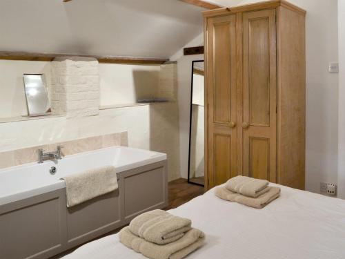 a bathroom with a sink and a bed with towels at Apple Loft in Hotham