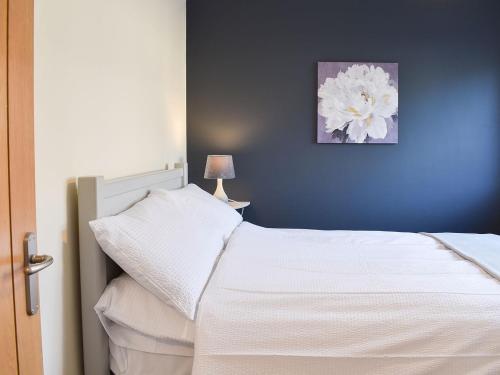 a bedroom with a white bed with a blue wall at One Dorchester Drive - Uk32037 in Inglewhite