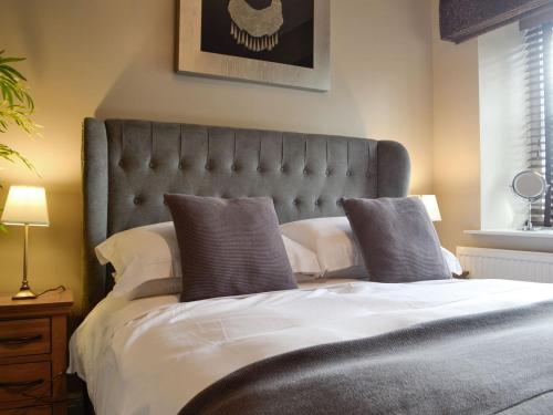 una camera da letto con un grande letto con due cuscini di The Apartment a Brecon