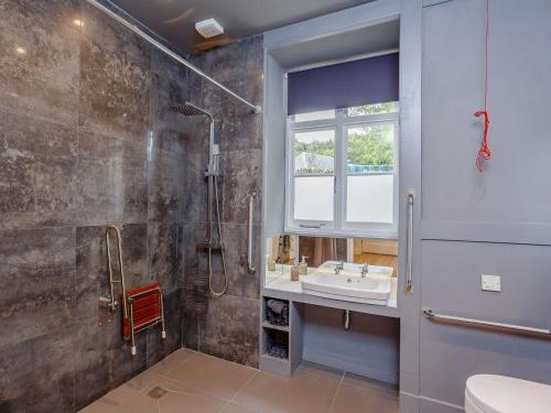 uma casa de banho com um lavatório e um chuveiro em Coillemore House em Balmacara
