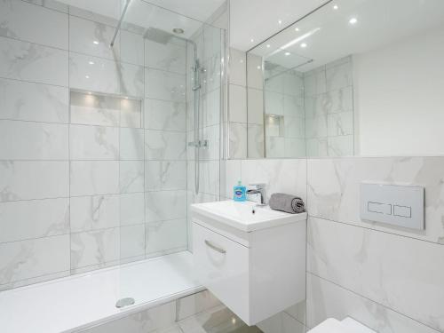 y baño blanco con lavabo y ducha. en Waterside Lodge Three - Uk33350 en Southowram