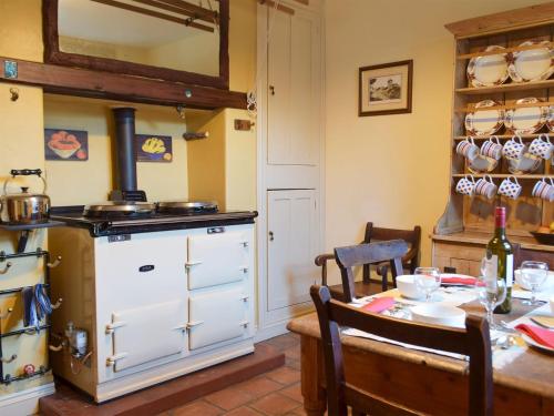 a kitchen with a table and a stove at Collingwood in Marloes