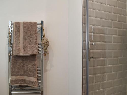 a towel rack with towels on it in a bathroom at Kingsley Cottage in Darenth