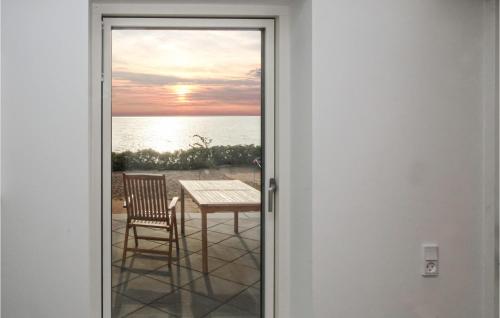 a door leading to a patio with a table and chair at 3 Bedroom Lovely Home In Samsø in Ballen