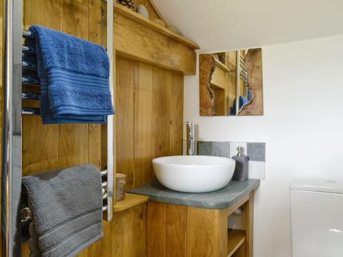 a bathroom with a bowl sink and blue towels at Springlea Cottage in Dean