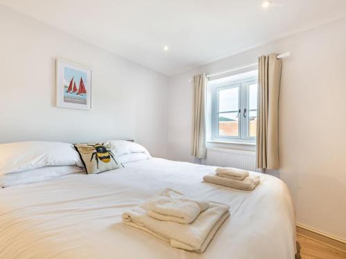 a bedroom with a white bed with towels on it at River View in Trimingham