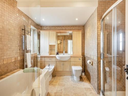 a bathroom with a tub and a toilet and a sink at River View in Trimingham