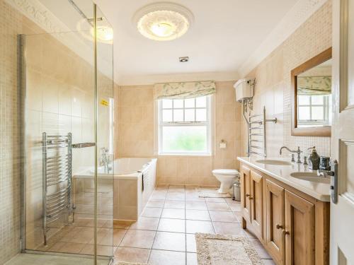 een badkamer met een douche, een bad en een wastafel bij Allerton House in Isham
