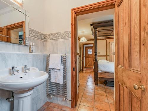 uma casa de banho com um lavatório e um espelho em The Stables - Uk30946 em Barthomley