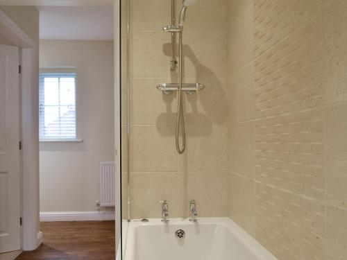 a bathroom with a shower and a bath tub at Croft Cottage 2 - Uk10588 in Stillington