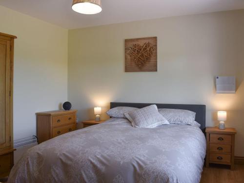 a bedroom with a large bed with two night stands at The Stables At Greenview in Winsham