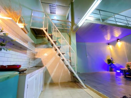 a spiral staircase in a kitchen with purple lighting at Cúc cu Homestay 3 in Kiến An