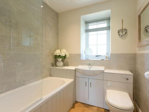 a bathroom with a tub and a sink and a toilet at The Barn - Uk2475 in West Witton