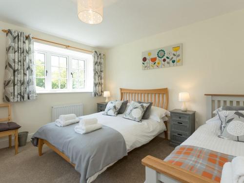 a bedroom with two beds and a window at The Barn - Uk2475 in West Witton