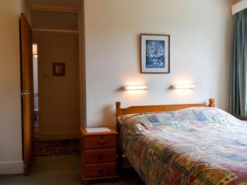 ein Schlafzimmer mit einem Bett und zwei Lampen an der Wand in der Unterkunft Honeybags-uk12422 in Widecombe in the Moor