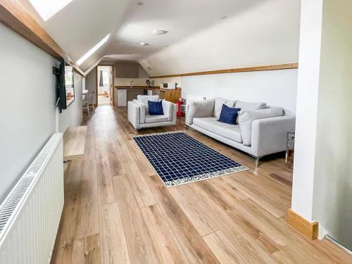 a living room with wooden floors and white furniture at The Oaks - Uk33998 in Child Okeford