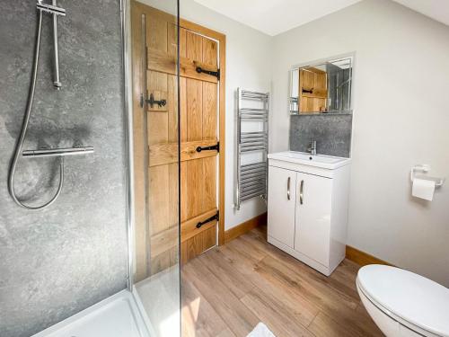 a bathroom with a shower and a toilet and a sink at The Oaks - Uk33998 in Child Okeford