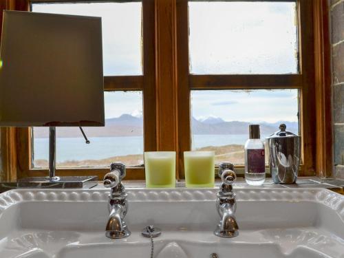 a bathroom sink with a window with a view of the ocean at Fearnmore Church in Fearnmore