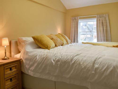 a bedroom with a white bed with a window at Dusty House in Ashbourne