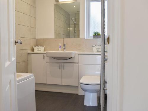 a bathroom with a toilet and a sink and a mirror at Caddie - Uk11038 in Carlyon Bay
