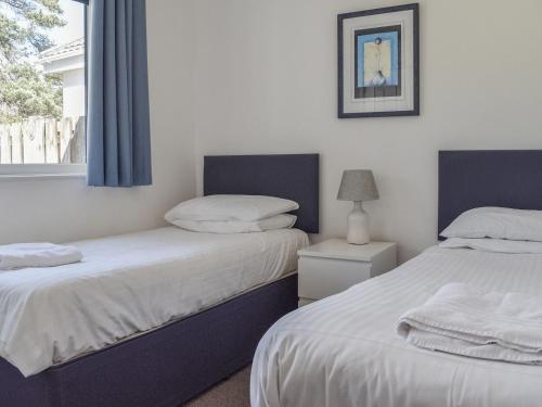 dos camas sentadas una al lado de la otra en un dormitorio en Caddie - Uk11038 en Carlyon Bay