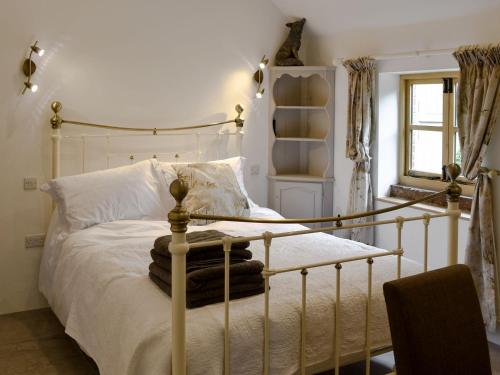 a bedroom with a white bed with a metal frame at Black Lion Folly in Rhydymwyn
