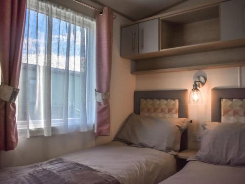 a bedroom with two beds and a window at The Endeavour - Uk37771 in Stoupe Brow