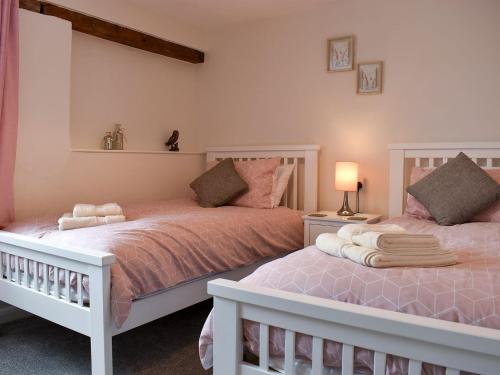 two beds sitting next to each other in a bedroom at The Dairy Barn in Burlescombe