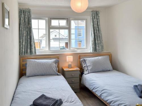 two beds in a room with two windows at Morolwg in Borth