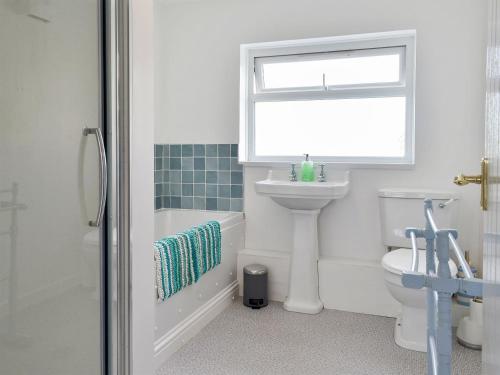 a bathroom with a sink and a toilet and a window at Morolwg in Borth