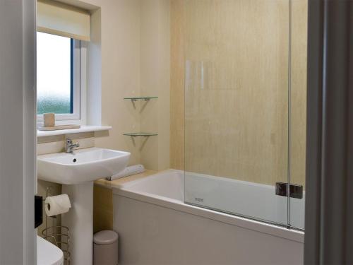 a bathroom with a sink and a bath tub and a sink at May Cottage - Uk12970 in Settle