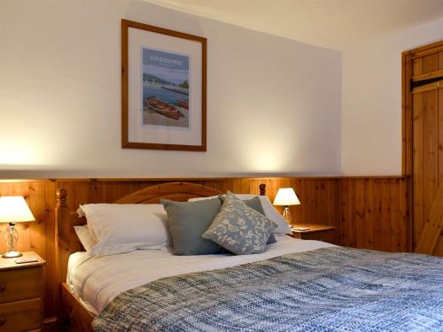 een slaapkamer met een bed met 2 lampen en een foto aan de muur bij Bell Hill Cottage in Lindale