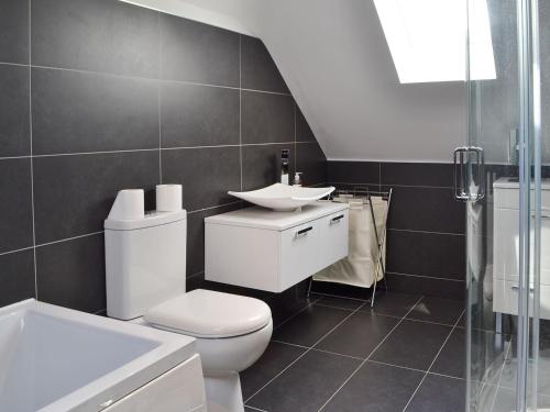 a bathroom with a white toilet and a sink at Quay House in Burton