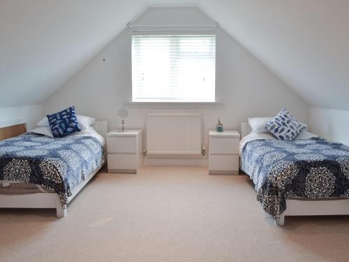 a attic bedroom with two beds and a window at Quay House in Burton